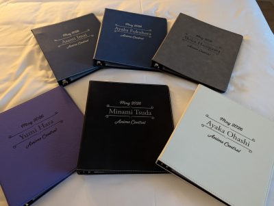 6 binders laid on a bed